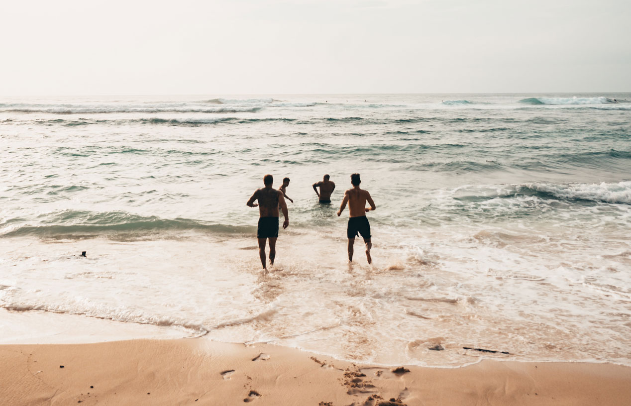 Personen rennen am Meer ins Wasser / Pexels
